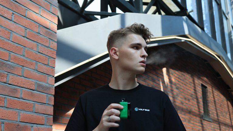 A boy smokes a volfbar e-cigarette